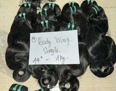Волнистые трессы Body Wavy чёрного цвета на столе с рукописными подписями длины и градации