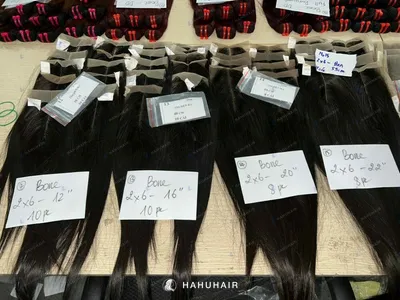 Lace closures with straight hair and handwritten size labels laid out on a table