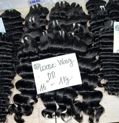 Loose wave black hair wefts on a table with handwritten length and grade labels