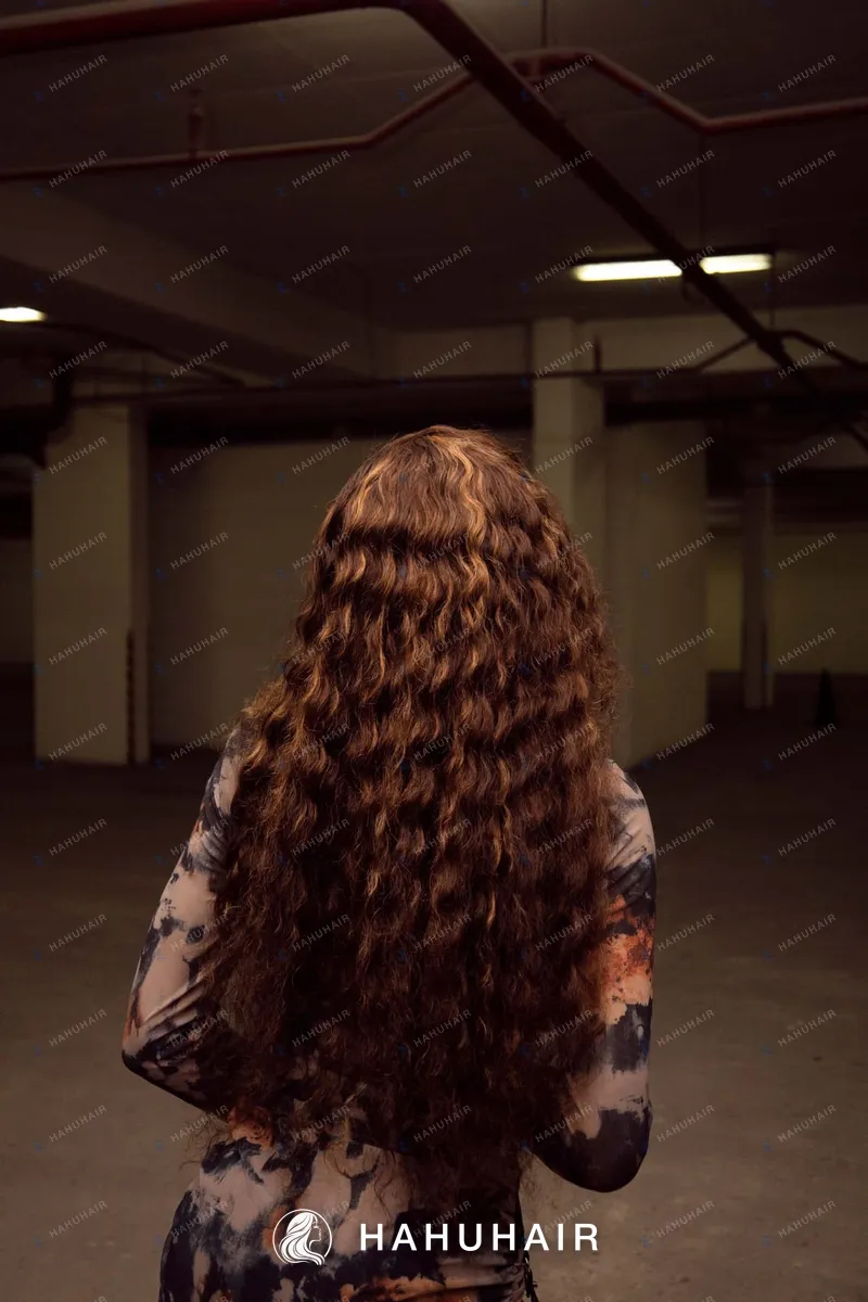 Long, tightly curled copper-brown hair seen from behind
