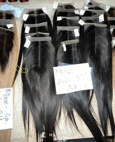 Lace closures with straight hair and handwritten size labels laid out on a table