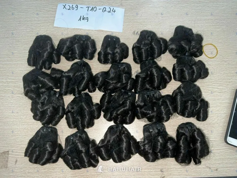 Трессы Bouncy Curl чёрного цвета, разложенные на столе