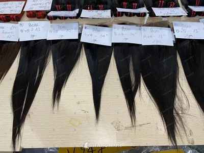 Lace closures with straight hair and handwritten size labels laid out on a table
