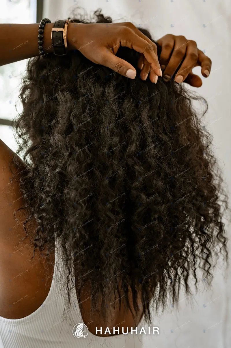 Long dark curly hair seen from behind, hands lifting the curls