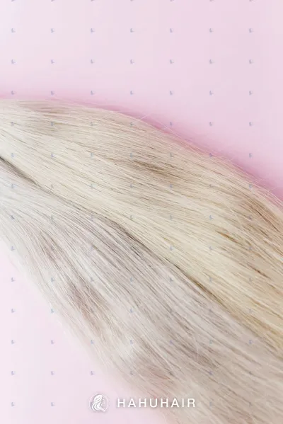 Close-up of straight light blonde hair on a pink background