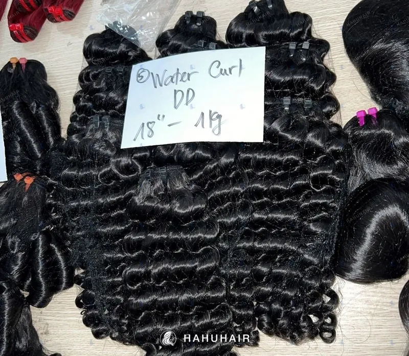 Кудрявые трессы Water Curly чёрного цвета на столе с рукописными подписями длины и градации