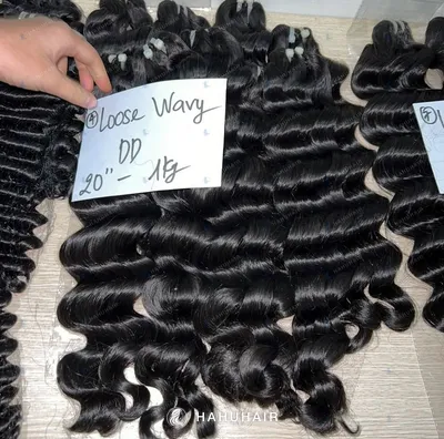 Loose wave black hair wefts on a table with handwritten length and grade labels