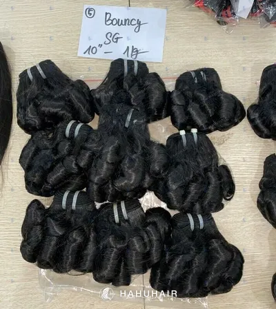 Bouncy curl black hair wefts laid out on a table